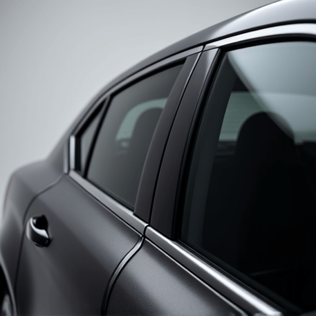 technician installing ceramic window tint on luxury car