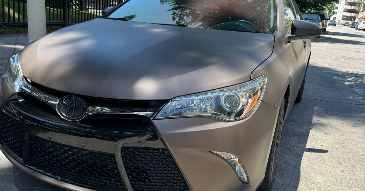 Toyota Camry with a matte brown vinyl wrap parked on a street in Los Angeles.
