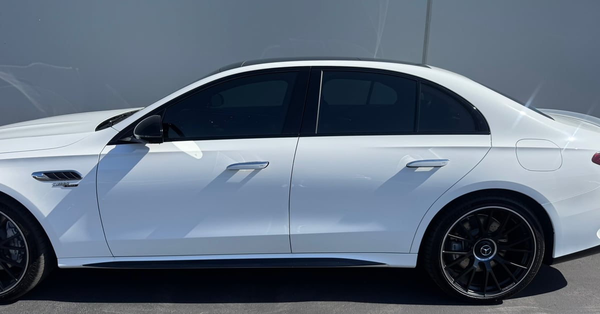 Side view of a white Mercedes-Benz with dark professional window tinting in Los Angeles.